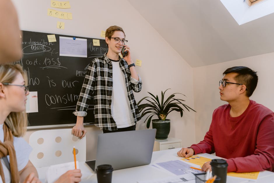 Young professionals engage in an informal office meeting, focusing on team collaboration and communication.