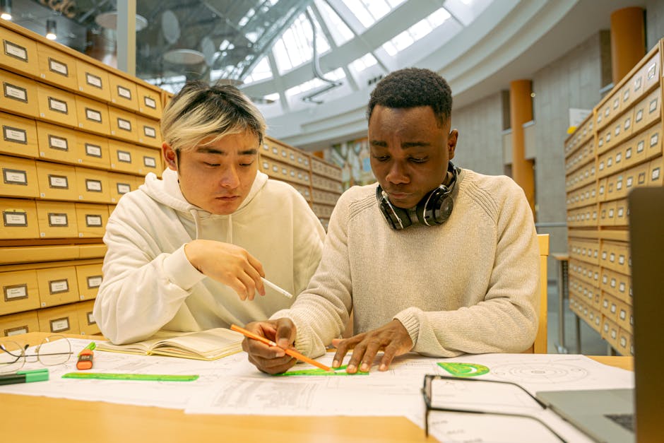 Two college students collaborating on a project in a modern library setting. Education and teamwork.