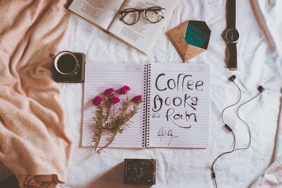 Overhead view of notepad with written inscription near earphones and wristwatch on creased fabric